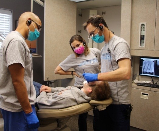 Three dental team member treating child under sedation dentistry