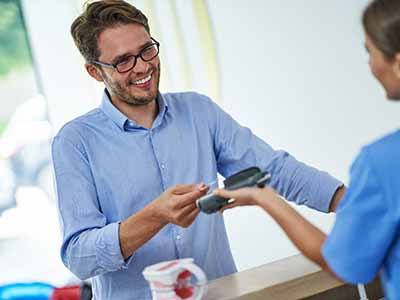 A man using a credit card to pay for dental treatment
