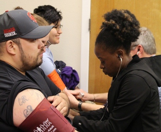 Dental team member checking patient vitals during community event