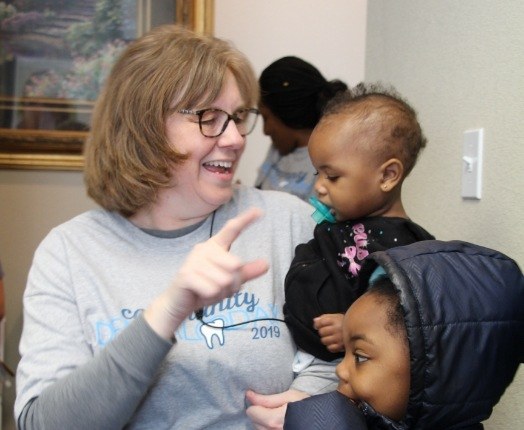 Dental team member laughing with children during community event