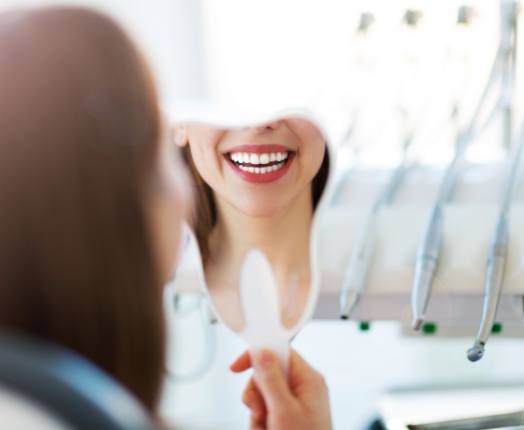 Woman looking at smile after makeover