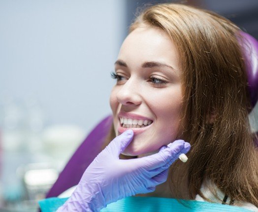 Dentist examining dentistry patient's smile after dental crown restoration