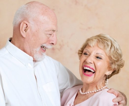 Man and woman with dentures smiling together