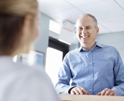 Man discussing the cost of dental emergencies with dentistry team member