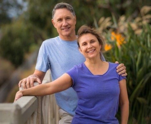 Man and woman enjoying the benefits of tooth replacement with dental implants