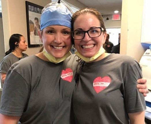 Two smiling dental team member celebrating oral cancer awareness month
