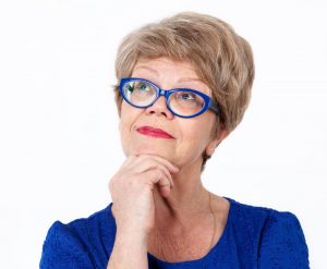 older woman blue glasses thinking