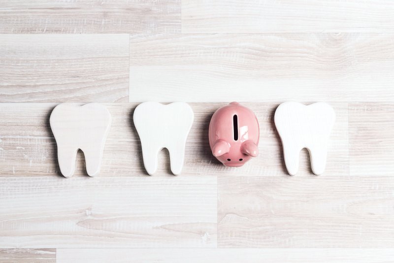 Piggy bank next to cardboard teeth