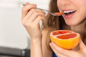 woman eating grapefruit