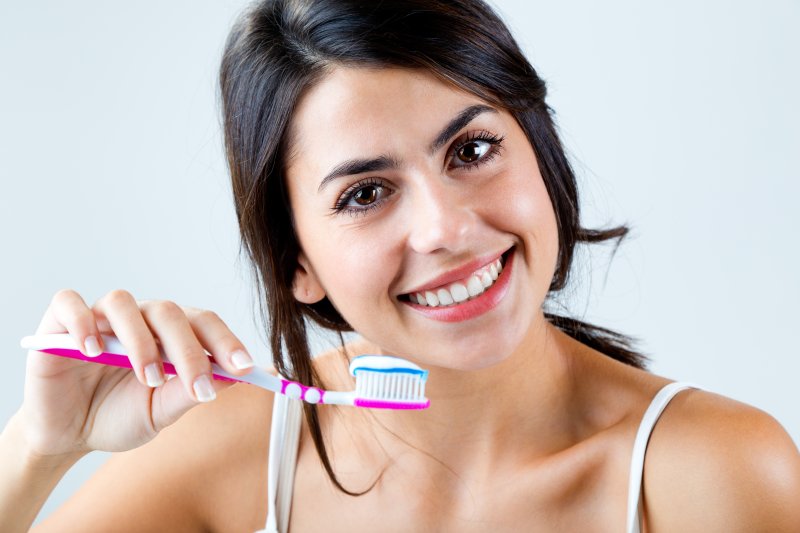 close up of young woman brushing her teeth