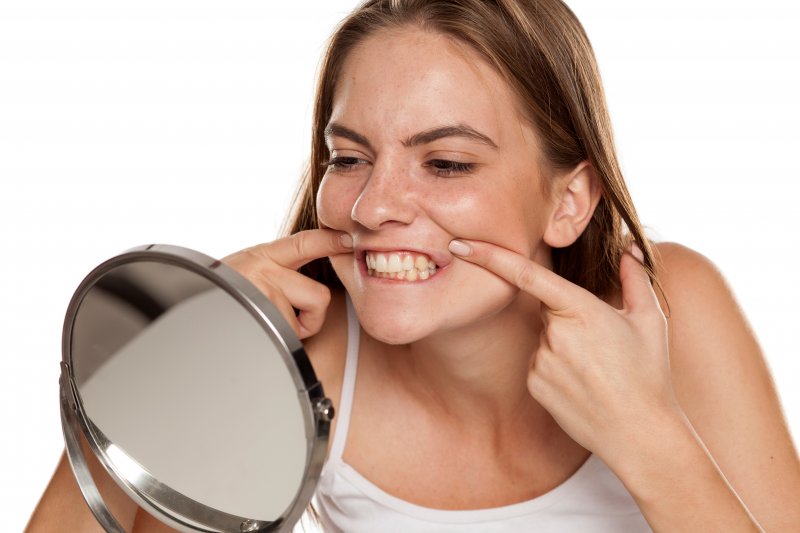 woman checking teeth and needing a dentist in Copperas Cove